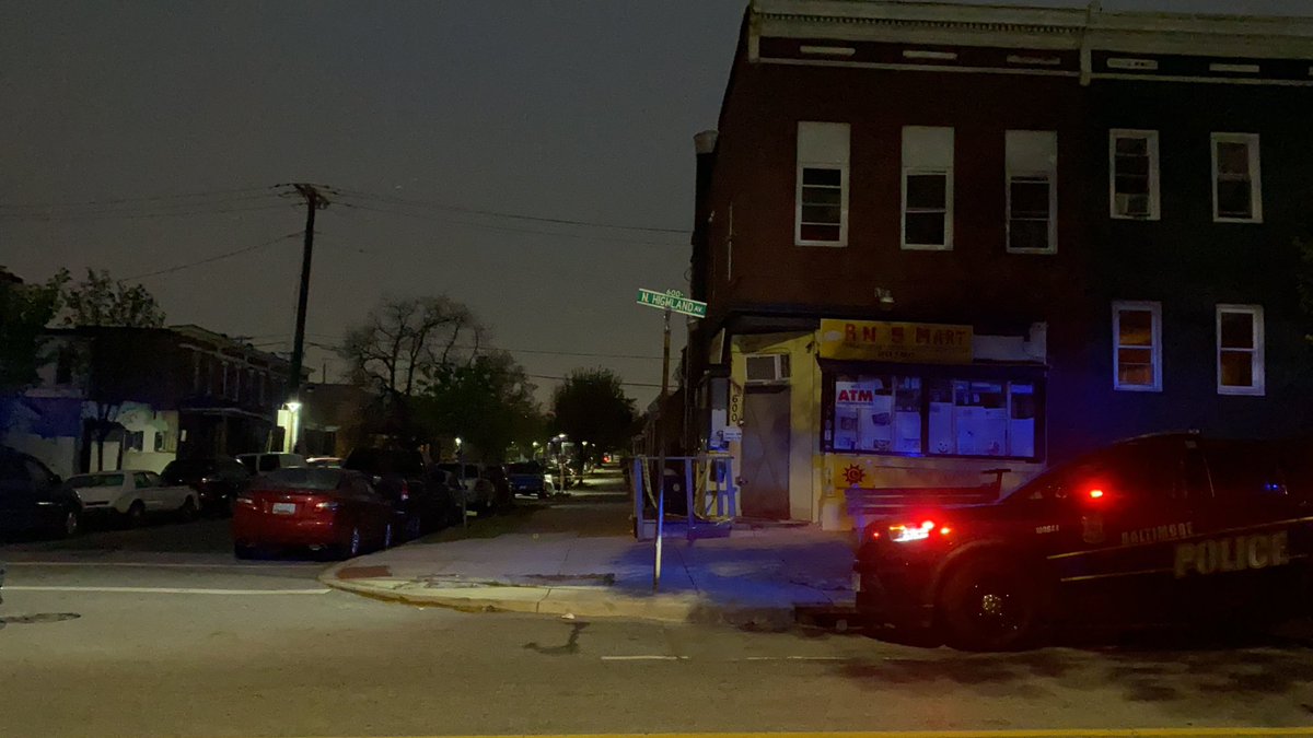 On scene of a reported shooting in East Baltimore. Officers are focused on the area outside a corner store at N Highland and McElderry. There are dozens of evidence markers and people gathered with blankets, hugging one another