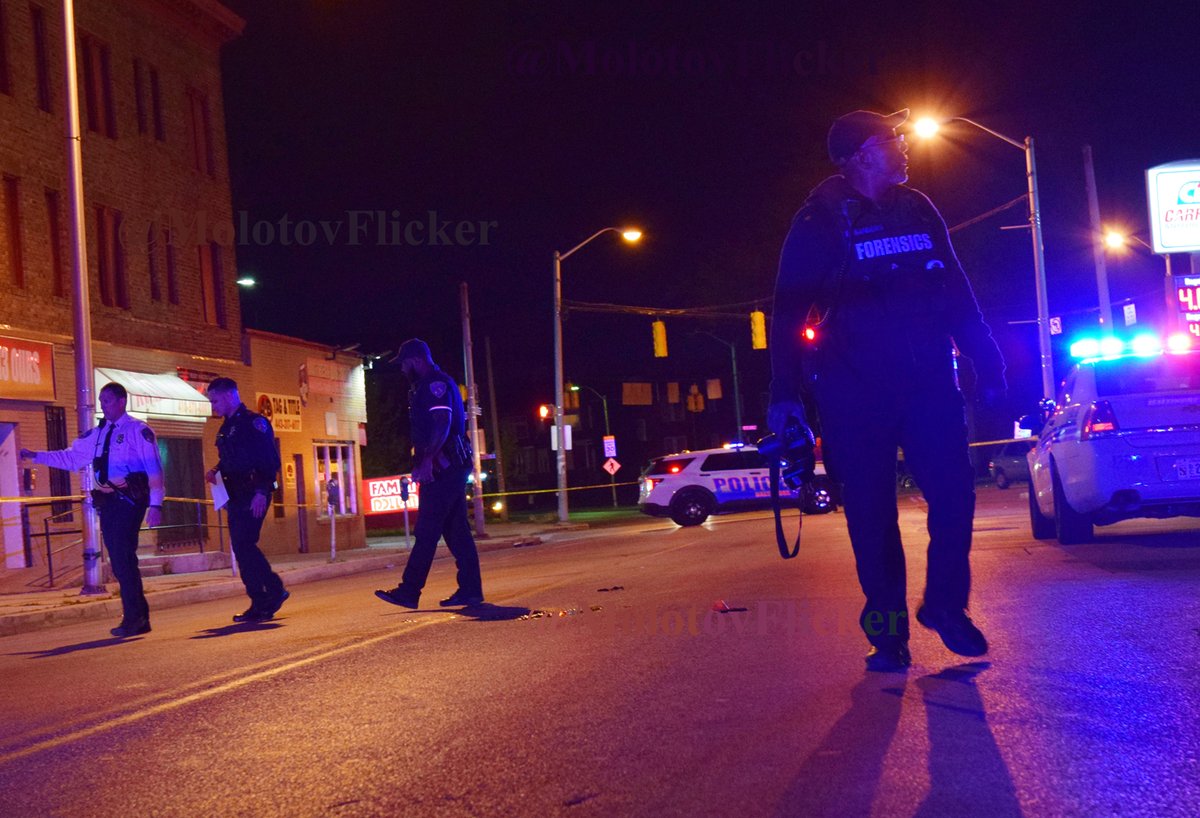 A crime lab technician surveys the 3300 block of Garrison Blvd for evidence of a shooting that killed two men Friday. Officers in Northwest Baltimore began receiving reports of the shooting around 8:45 p.m. The men were taken to Sinai Hospital where they died from their injuries