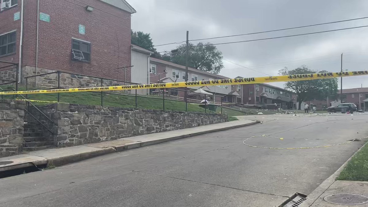 This is the aftermath of where the block party was when shots were fired. People are trying to sweep up the debris like cups and paper. However, you can see caution tape is still blocking this area