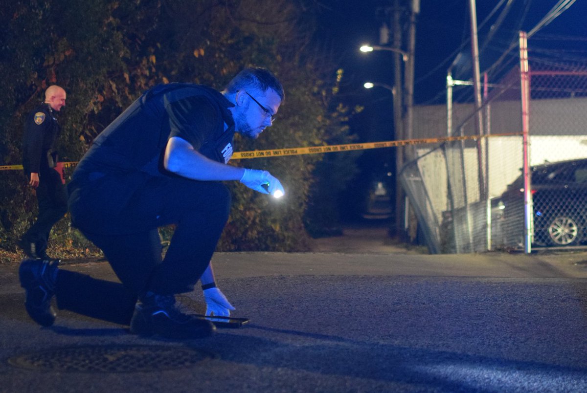 A crime lab technician searches for evidence of gunfire after a 46-year-old man was shot and killed in the 4200 block of Powell Avenue