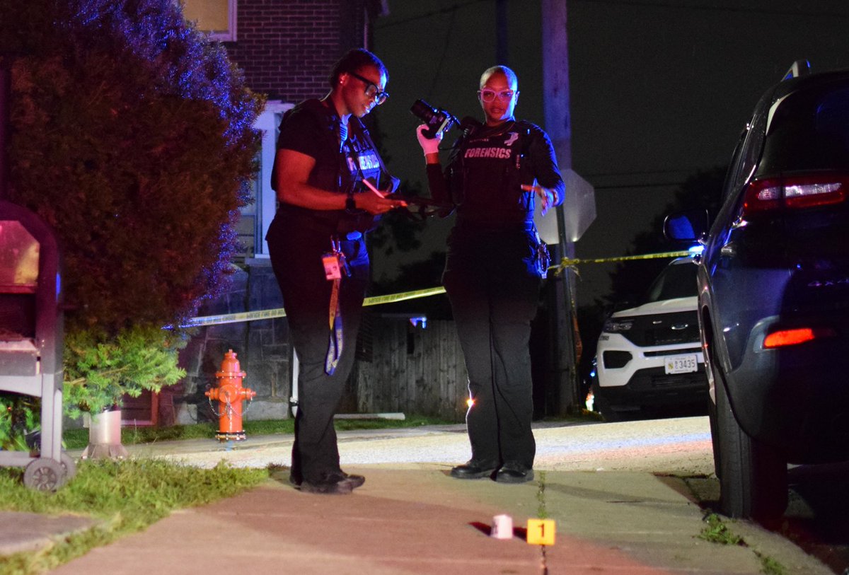 Crime lab technicians examine the spotlight where a 35-year-old man was shot in Baltimore's Belair-Edison neighborhood on Wednesday. The shooting happened near the intersection of Kavon Avenue and Brendan Avenue
