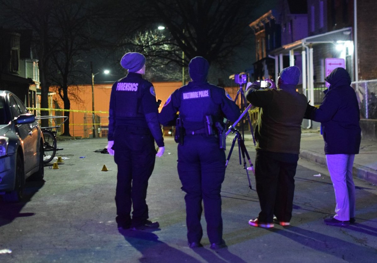 Homicide detective Eric Ragland takes a picture of the spot where a male was fatally shot on Friday. The shooting happened in the 500 block of East 26th Street around 8:20 p.m. This is the third deadly shooting on the block within the past decade