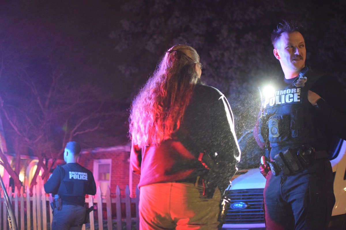 Officers talk to residents of Baltimore's Medfield neighborhood after a juvenile boy was fatally shot inside a home in the 1400 block of West Old Cold Spring Lane