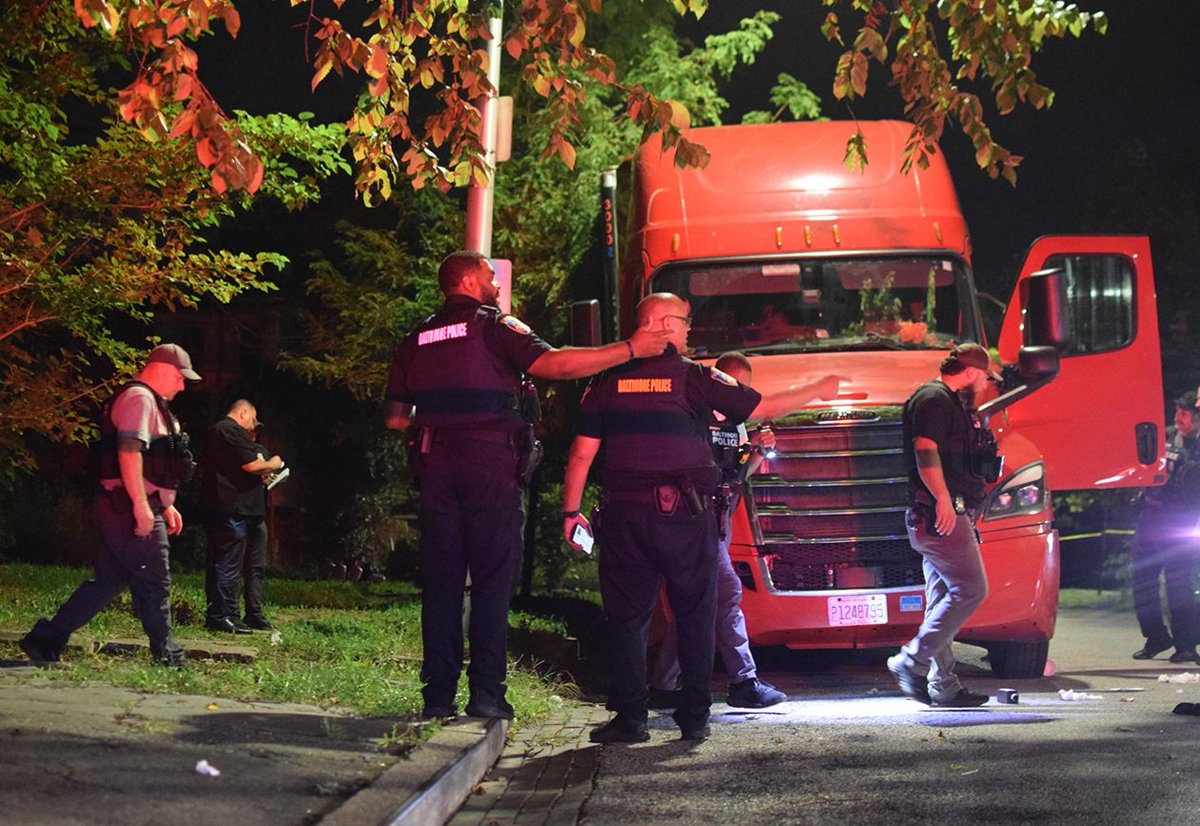 Baltimore police examine a tractor-trailer truck and search for evidence of gunfire following a shooting that injured a 45-year-old man in the 3100 block of Westwood Avenue on Wednesday night